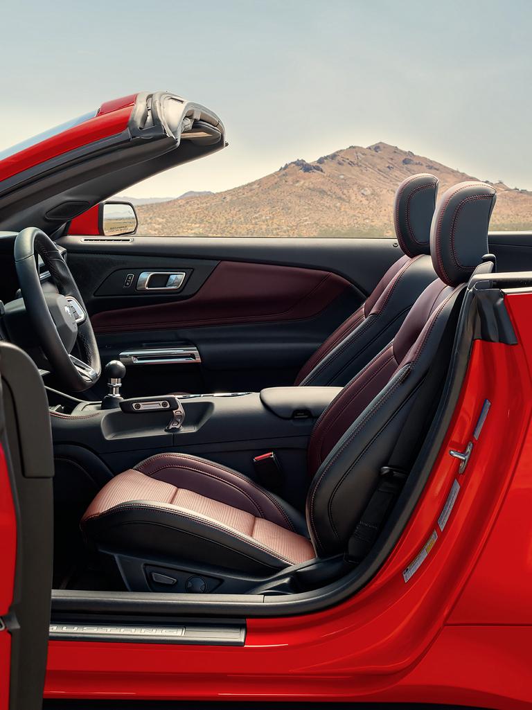 Ford Mustang® 2026 décapotable stationnée avec la portière du côté conducteur ouverte montrant l’intérieur rouge carmin en option