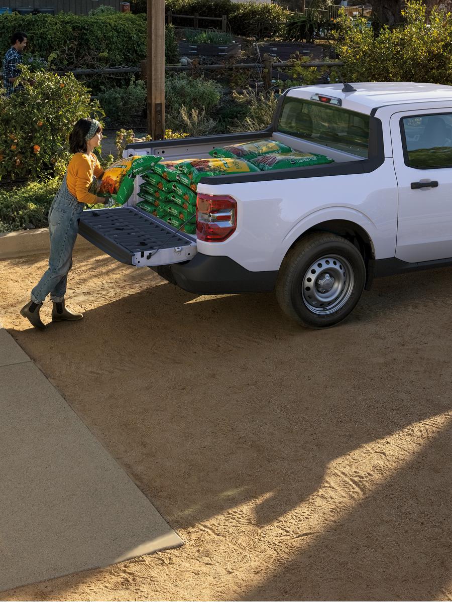 Deux personnes chargent la caisse d'un camion Maverick.