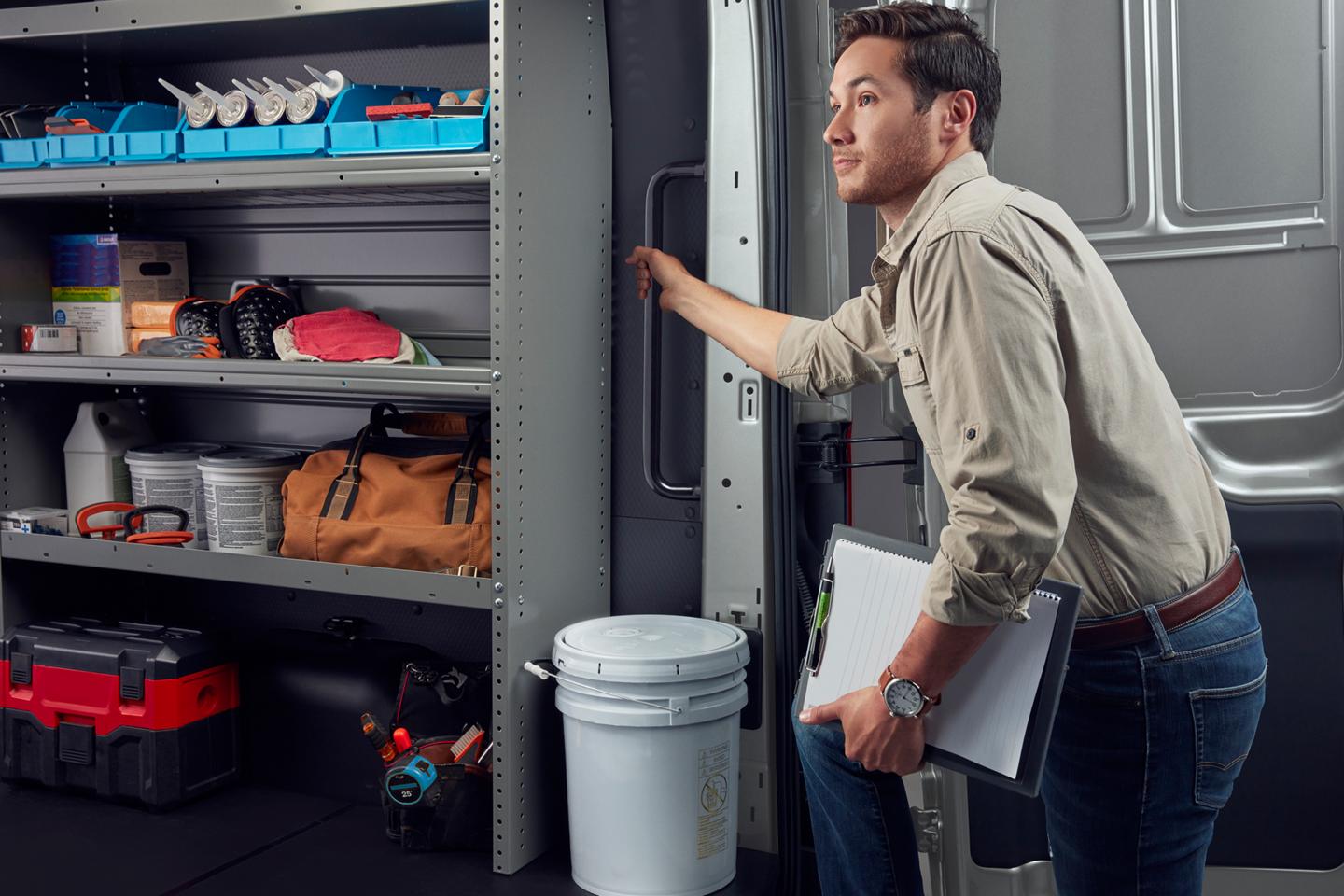 Une personne de métier entrant par les portes arrière d’une fourgonnette Ford Transit® 2026