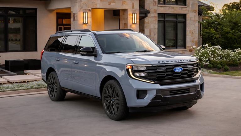 VUS Ford Expedition® Platinum™ 2027 avec ensemble de performance Stealth en option stationné dans une entrée de maison