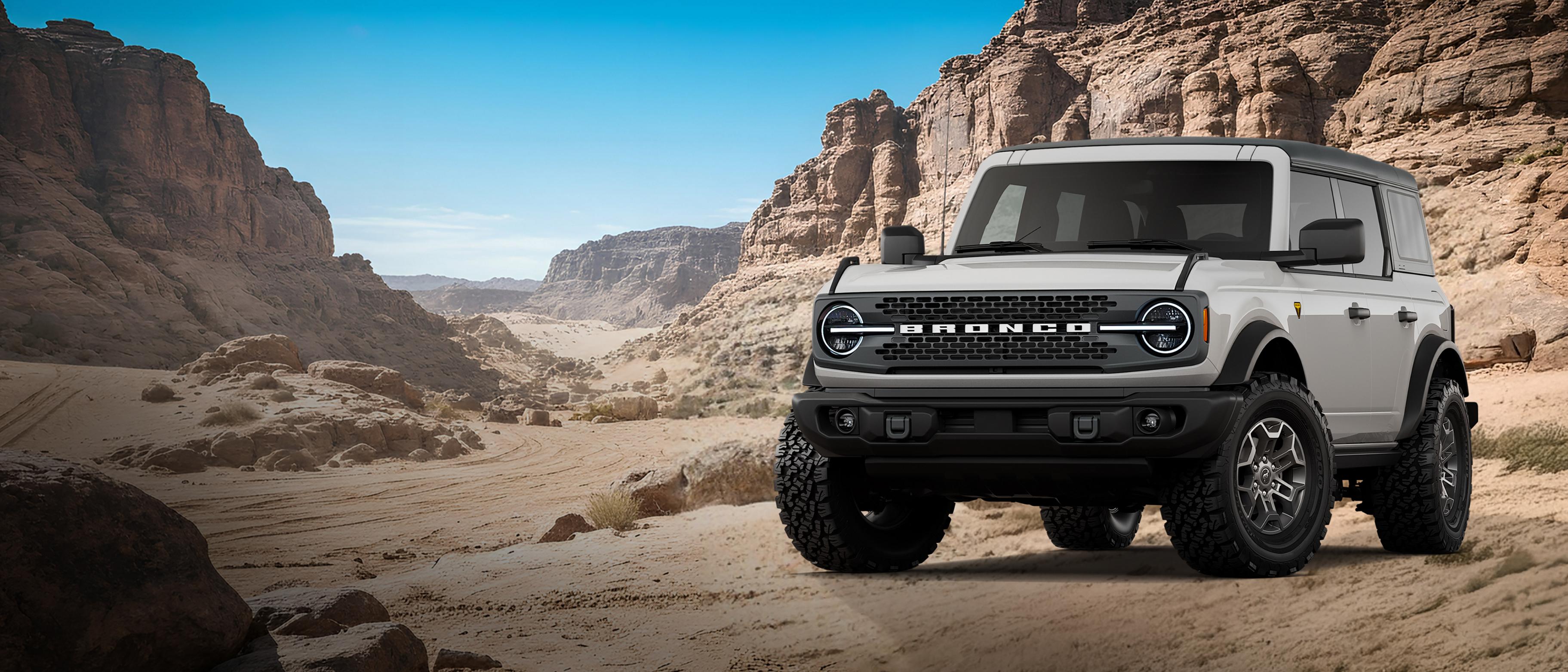 Un modèle Ford Bronco® Badlands 2026 présenté en gris avalanche stationné sur une étendue rocheuse