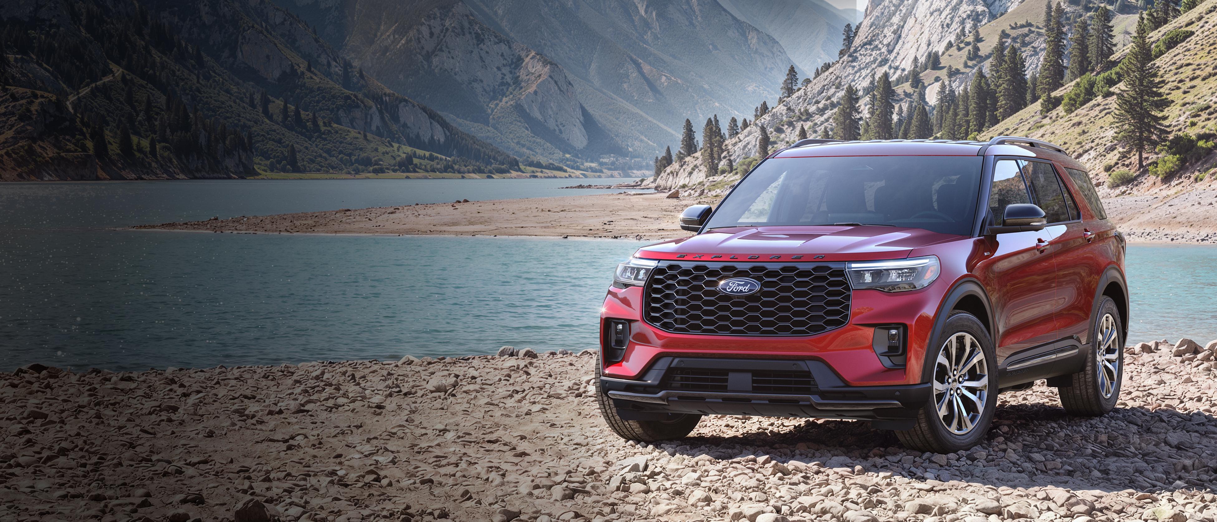 Un modèle Ford Explorer® ST-Line 2027 stationné sur une étendue rocheuse, près d’un lac de montagne