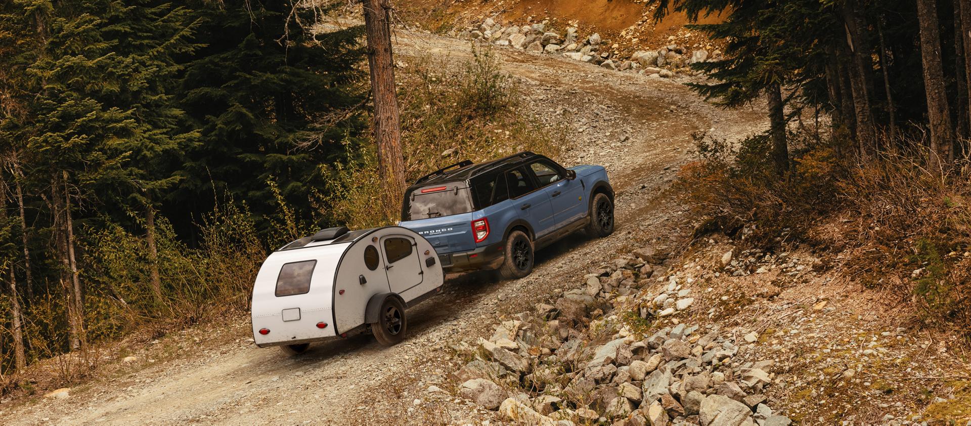 VUS Ford Bronco Sport® 2026 tirant une remorque sur une route de gravier de montagne