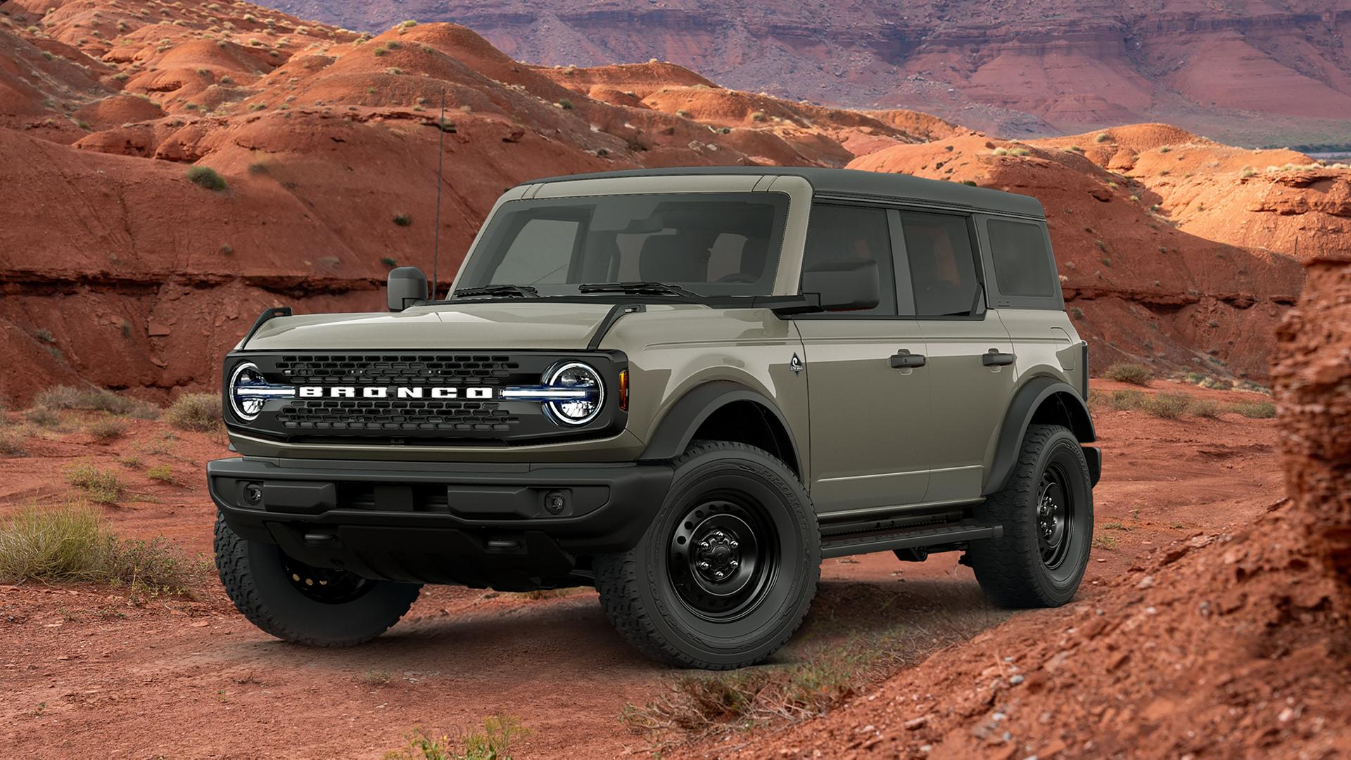 Un VUS Ford Bronco® 2026 équipé de l’ensemble décor Black en option, garé devant une mesa rouge