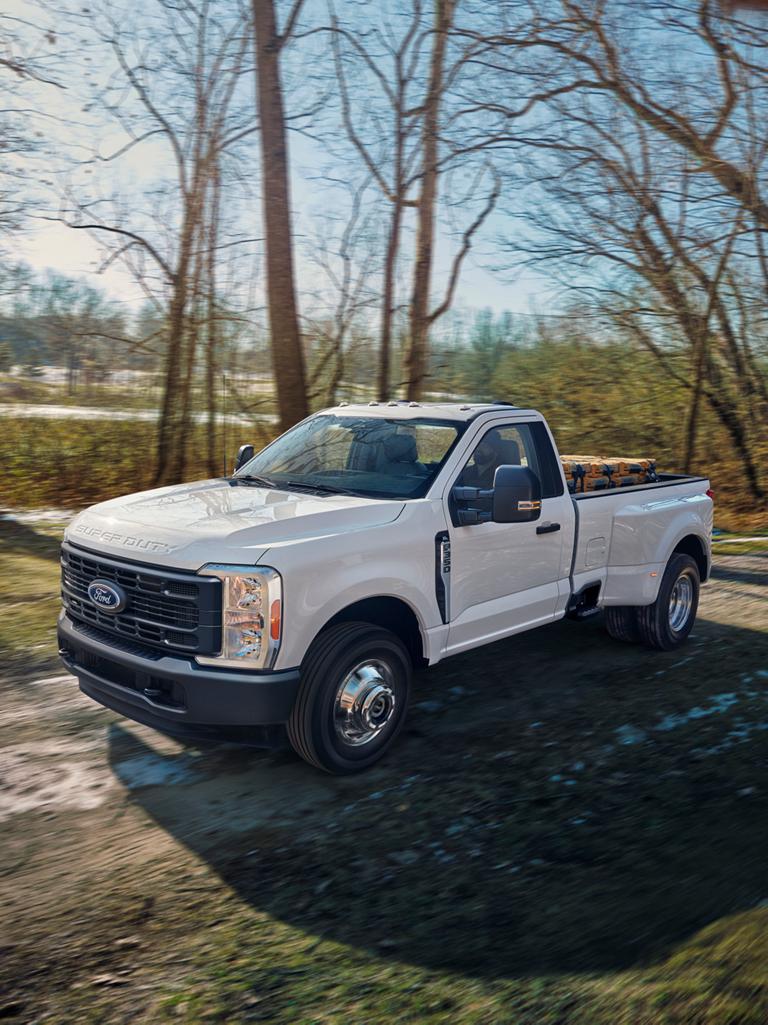 Ford Super Duty® F-350® XL 2026 roulant sur un chemin de terre avec le plateau chargé à pleine capacité.