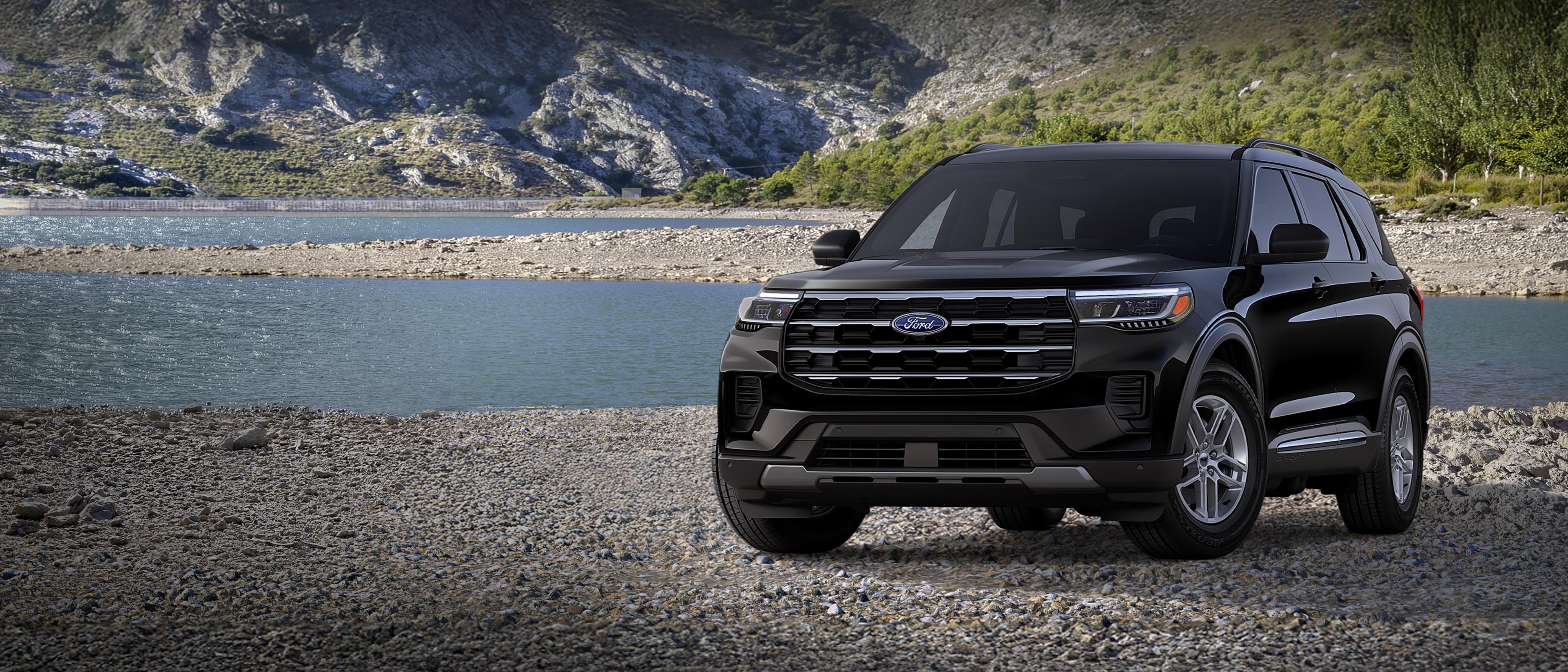 Un modèle Ford Explorer® Active 2026 stationné sur une étendue rocheuse, près d’un lac de montagne