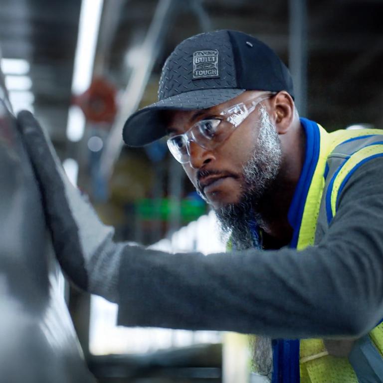 Un employé de Ford travaille sur un véhicule.