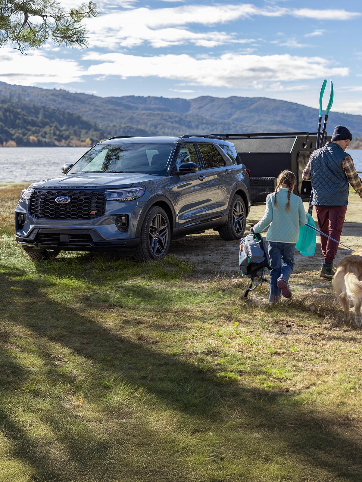 Un Ford Explorer® gris stationné près d'un lac, avec une remorque attelée à l'arrière.