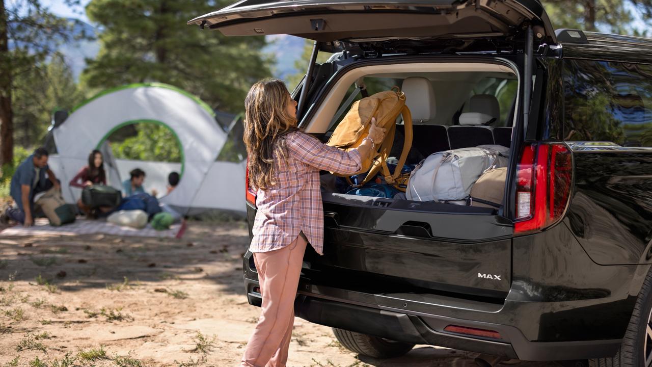 Personne chargeant des sacs dans la zone de chargement arrière d’un VUS Ford Expedition® MAX Platinum™ 2027