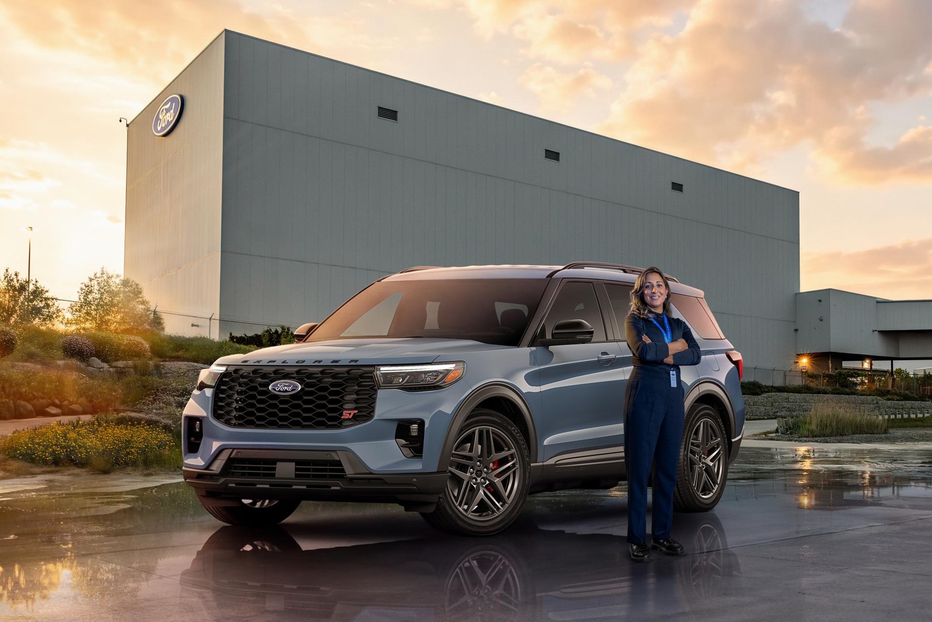 Un employé Ford debout près d’un véhicule Ford.