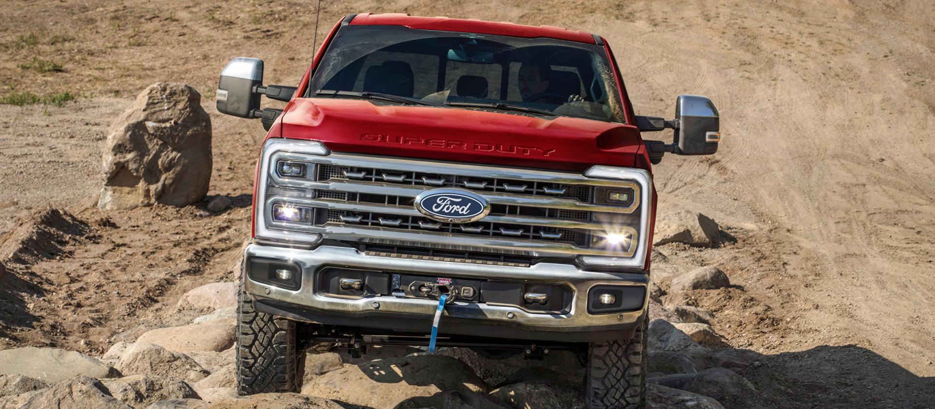 Camionnette Ford Super Duty® F-250 2027 avec l’ensemble hors route Tremor® circulant sur un terrain rocheux