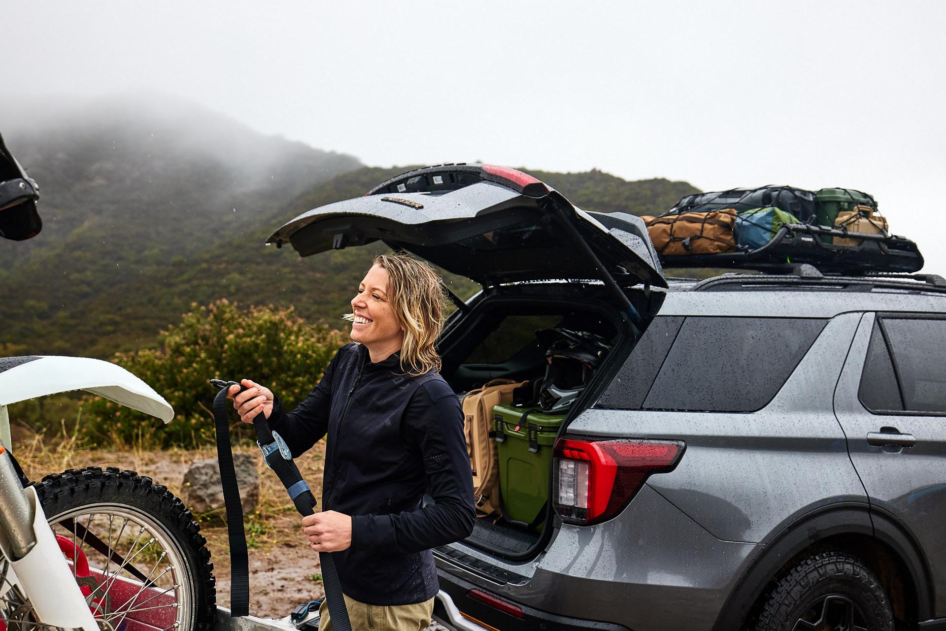 Une femme en train de décharger du matériel de loisirs à l'arrière d'un SUV Ford Explorer® Tremor®