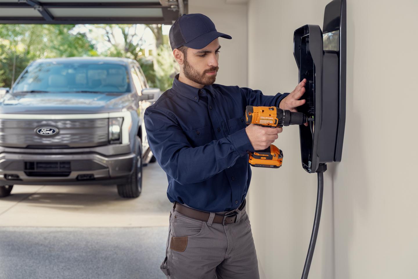 Technicien de service installant un chargeur domestique dans un garage résidentiel