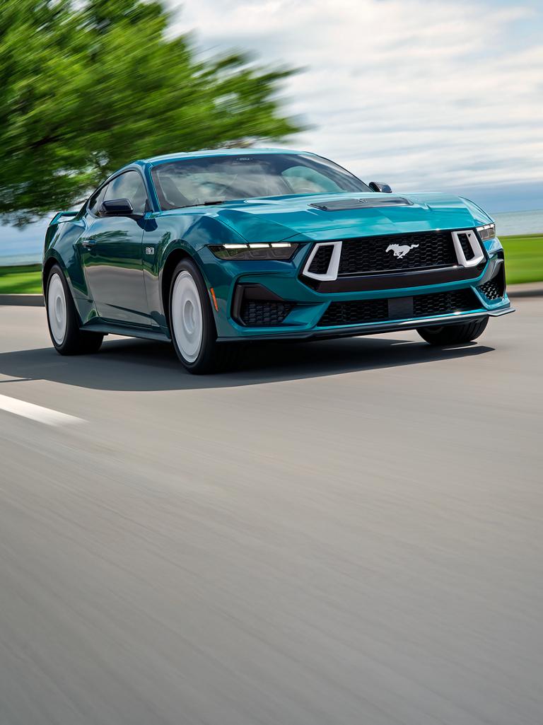 Un modèle Ford Mustang® GT Premium fastback 2026 avec ensemble FX en option circulant près d’un lac