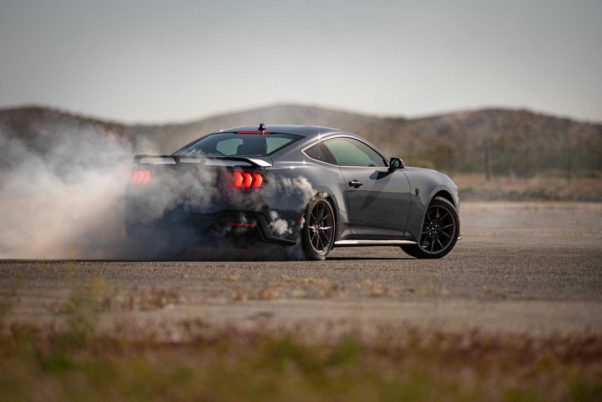 Ford Mustang Dark Horse® Coupé 2026 en bleu vapeur métallisé avec un conducteur professionnel faisant crisser ses pneus sur un parcours fermé