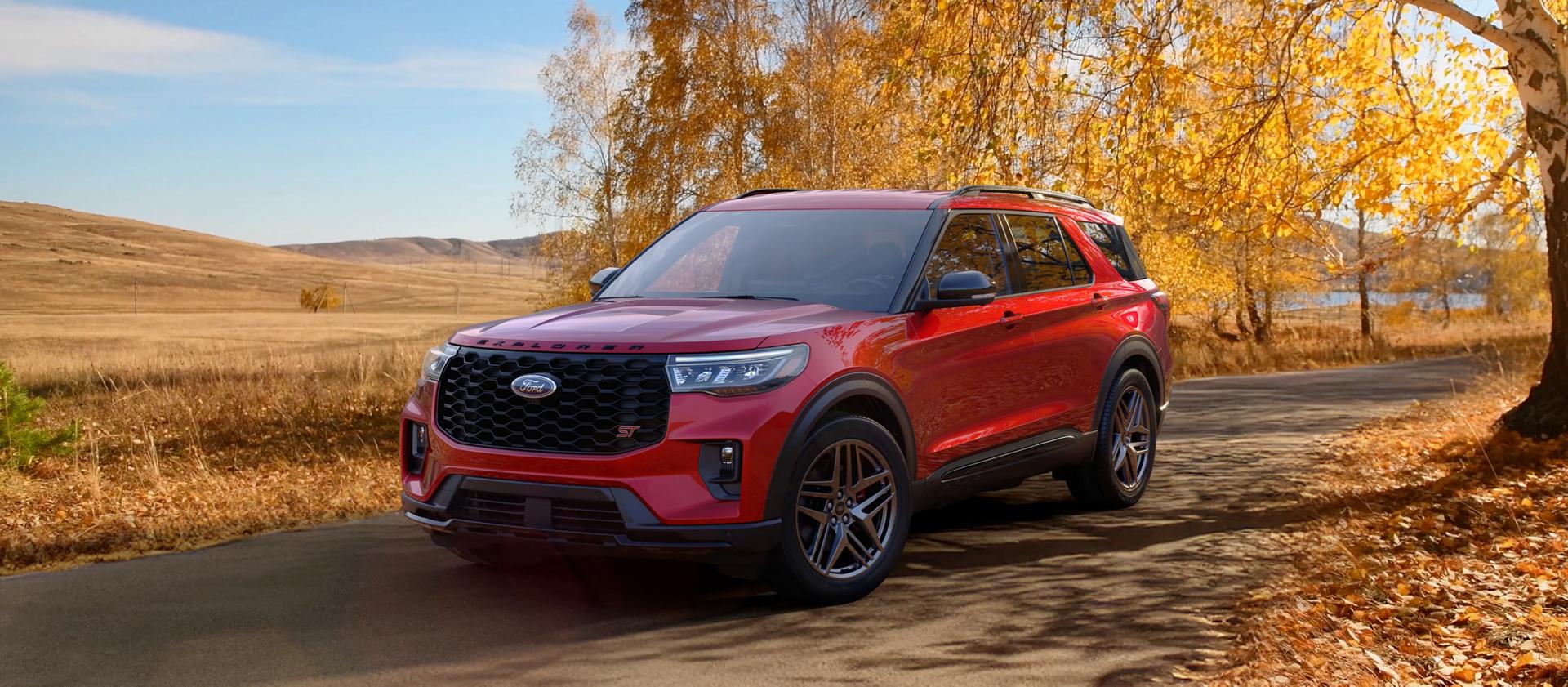 Un VUS Ford Explorer® 2026 sur une route à travers un champ à l’automne