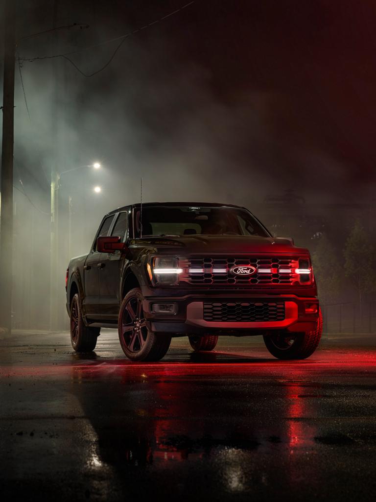 Camionnette Ford F-150 Lobo™ 2026 stationnée la nuit sous des lampadaires