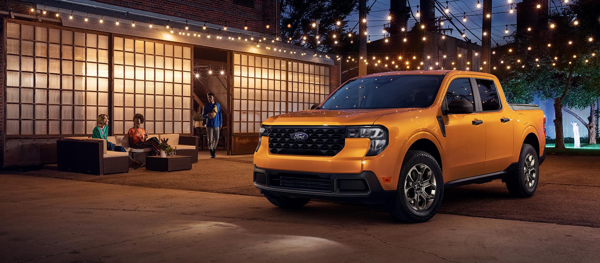 Camionnette Ford Maverick® 2026 stationnée sous des guirlandes lumineuses la nuit