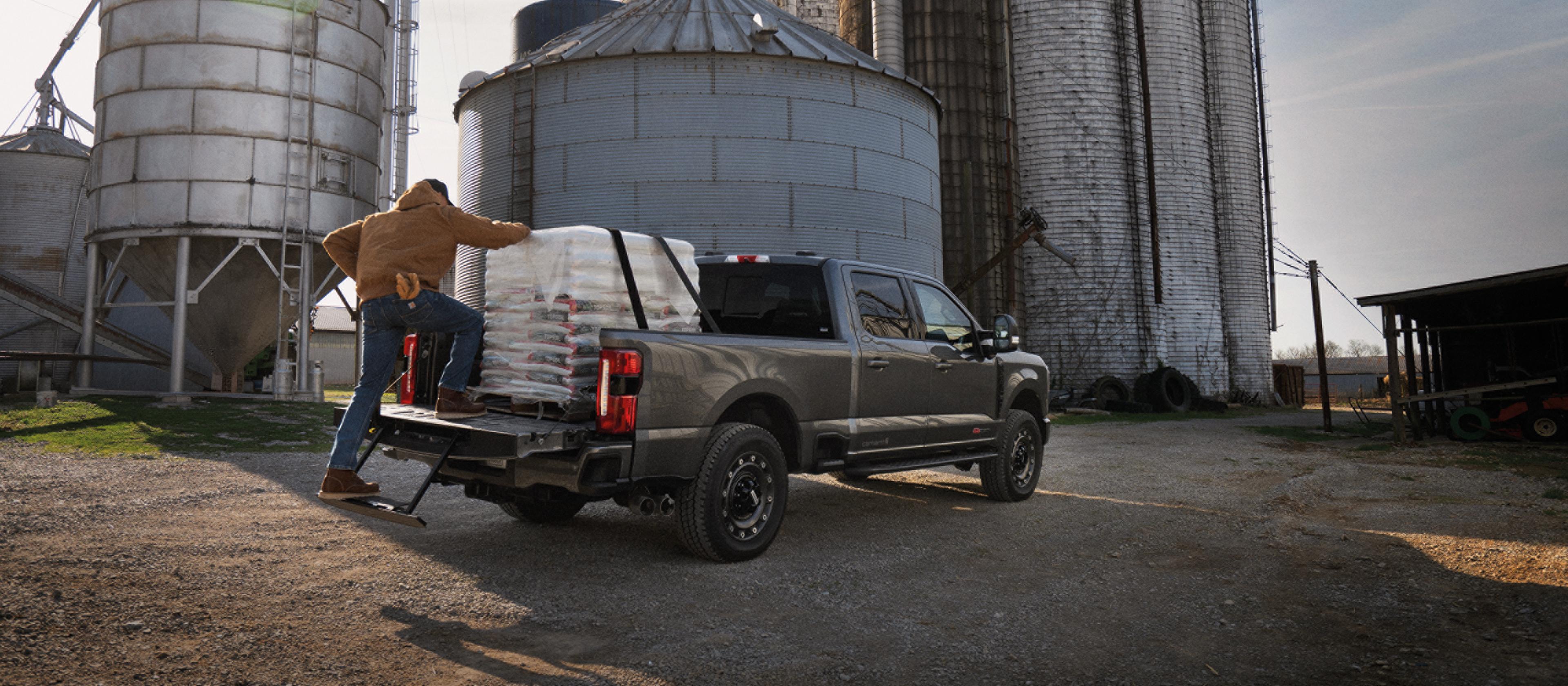 Une personne monte dans le plateau de son modèle Ford Super Duty® F-350® XLT 2027 équipé de l'ensemble Super Duty Carhartt®