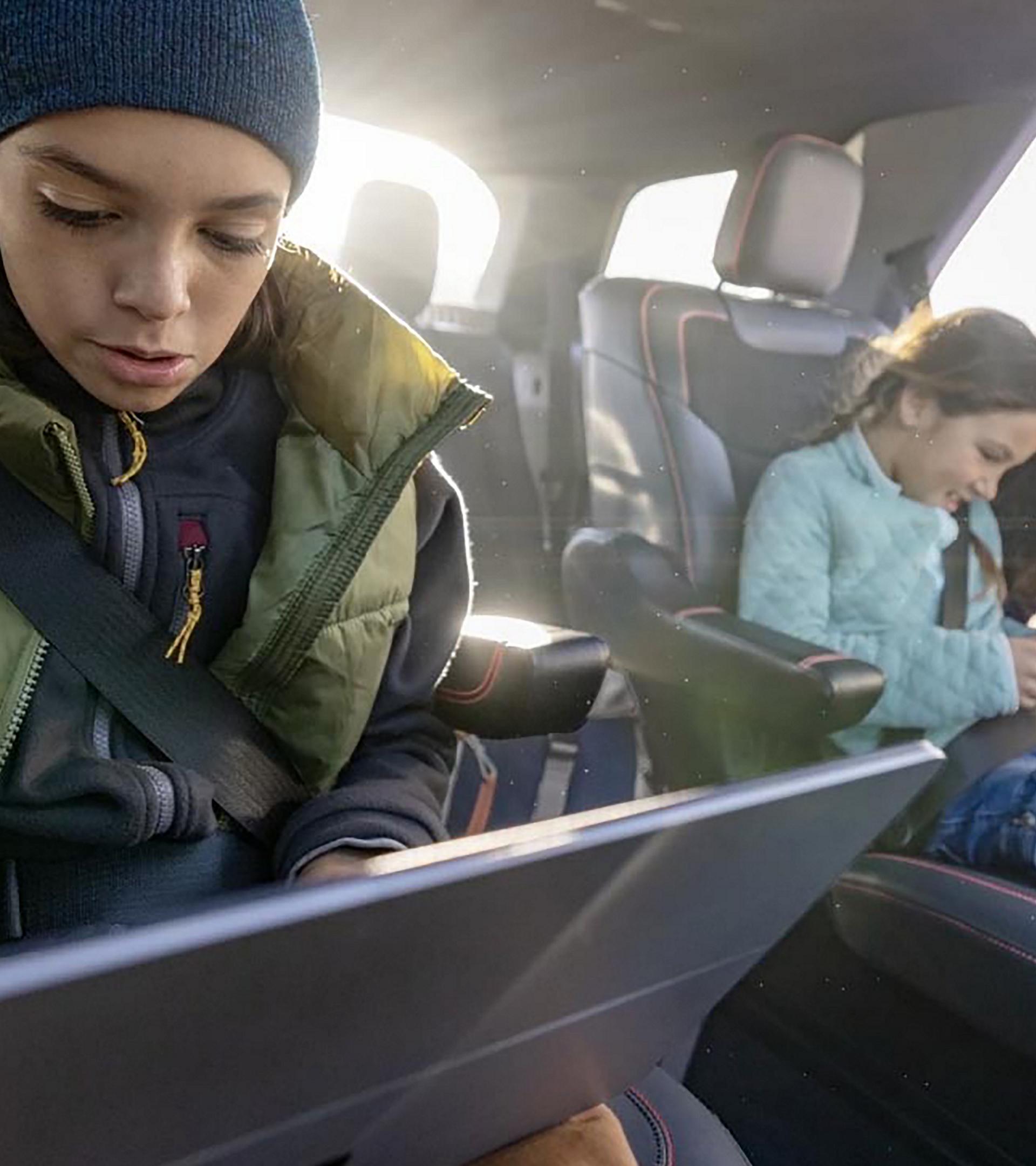 Deux enfants utilisant des appareils connectés sur les sièges de deuxième rangée d’un VUS Ford Explorer® 2027