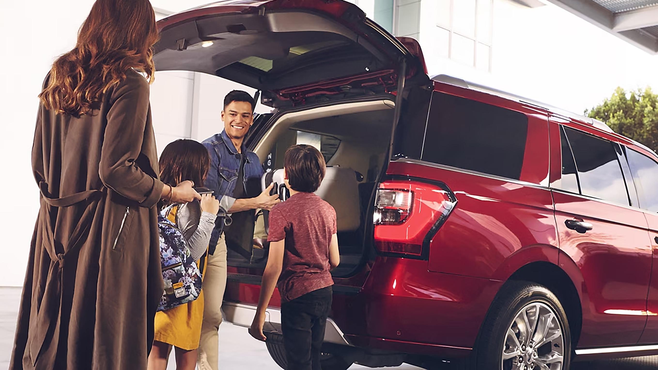 Une famille décharge des bagages d’un VUS Ford Expedition devant un hôtel.