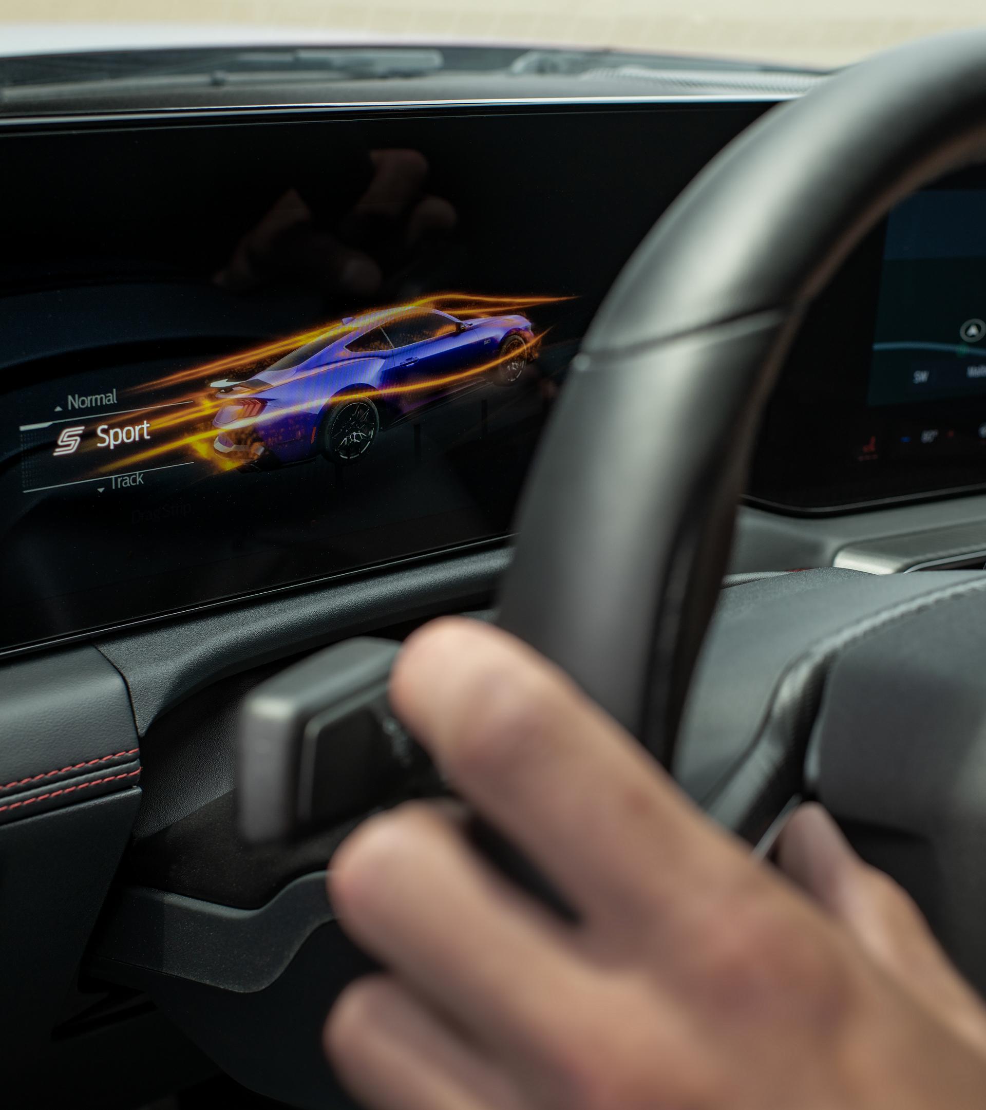 Main du conducteur sur le volant d’une Ford Mustang® 2026 avec tableau de bord numérique