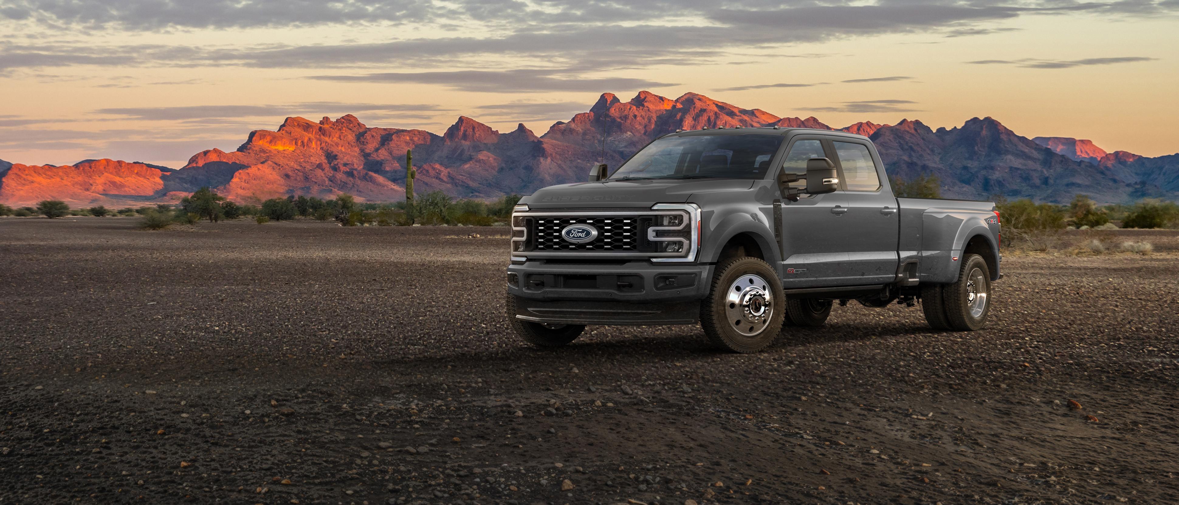 Camion Ford Super Duty F-450 Platinum 2027 stationné sur un chemin de terre montagneux.