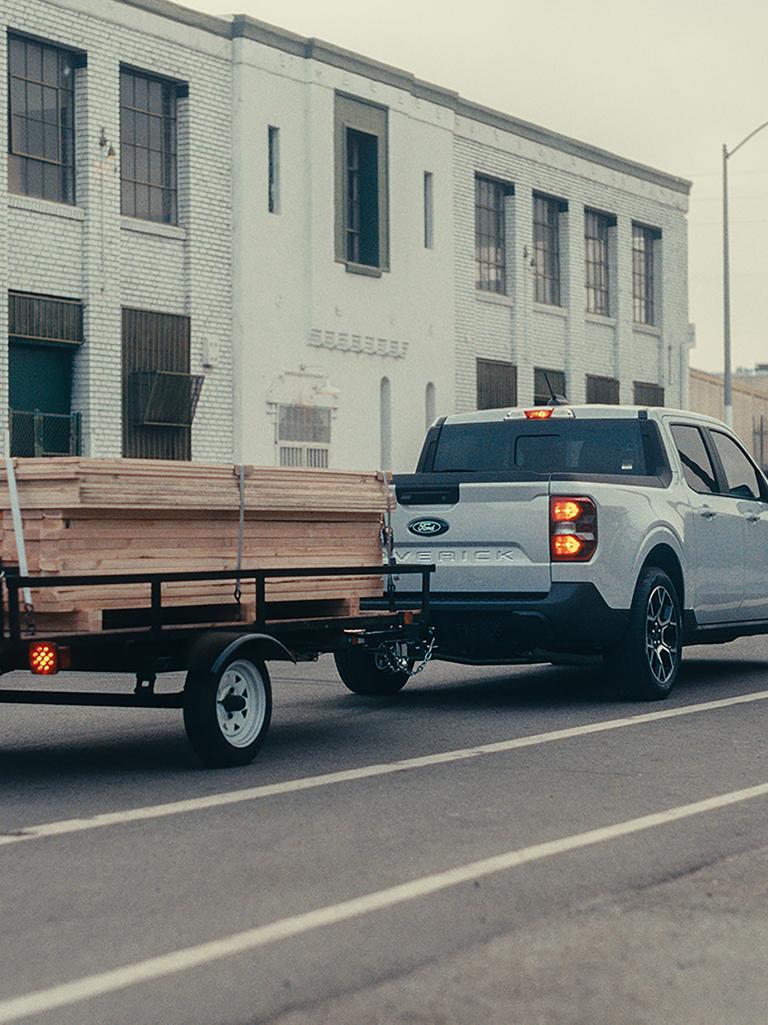 Camionnette Ford Maverick® XLT 2026 tirant une remorque et chargée avec une palette lourde de planches
