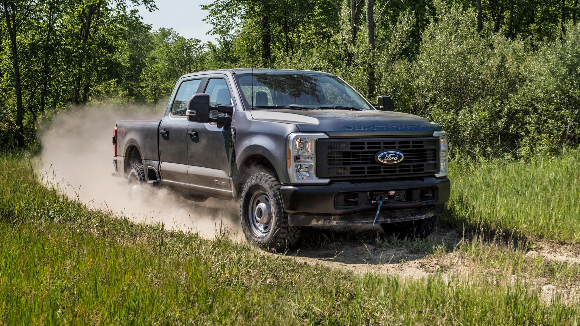 Modèle Ford Super Duty® F-250® XL 2026 en gris carbonisé tirant une caravane sur une route pavée