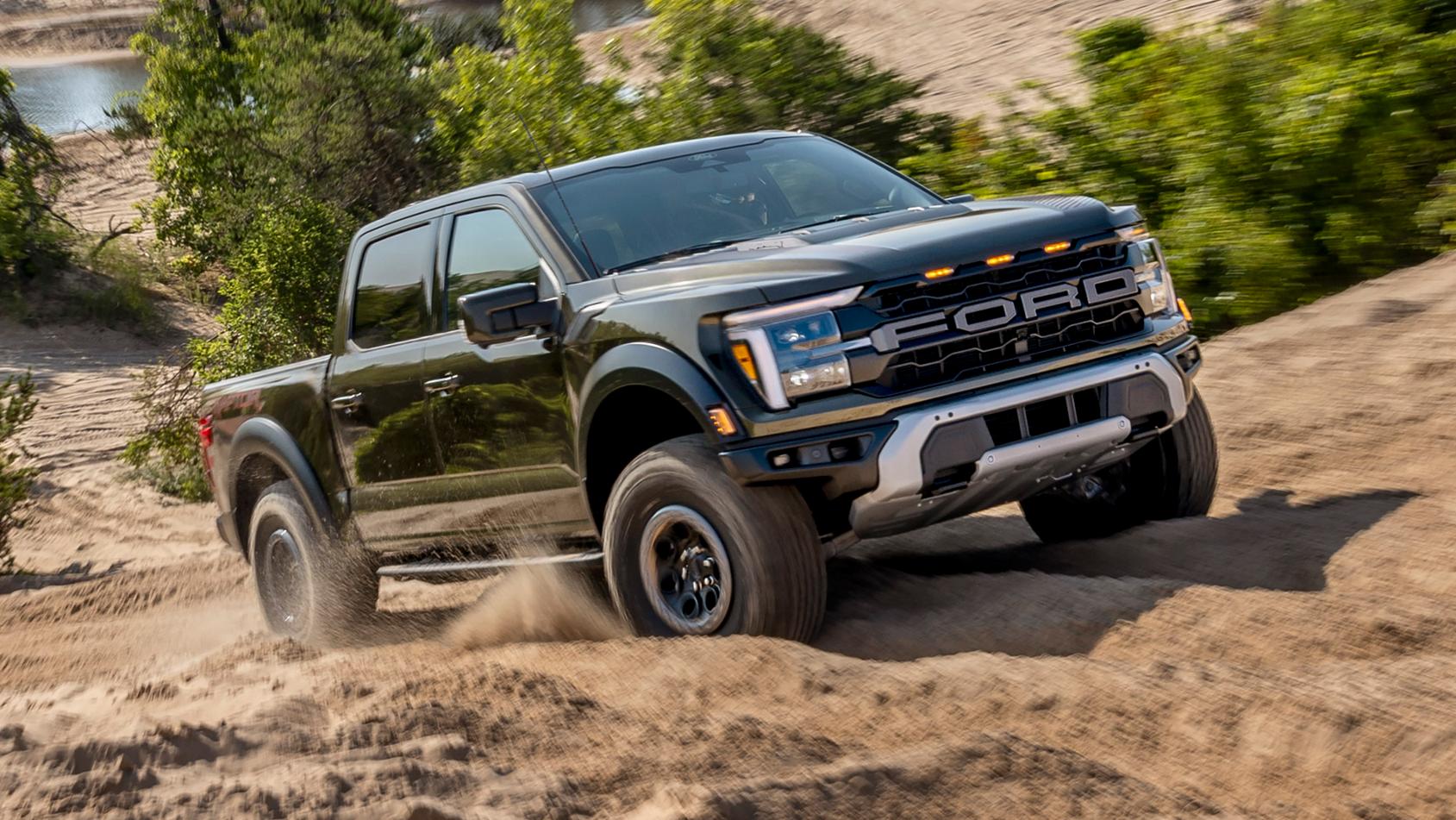 Camion Ford F-150® Raptor® 2025 en vert abri métallisé circulant sur un chemin rocheux dans le désert