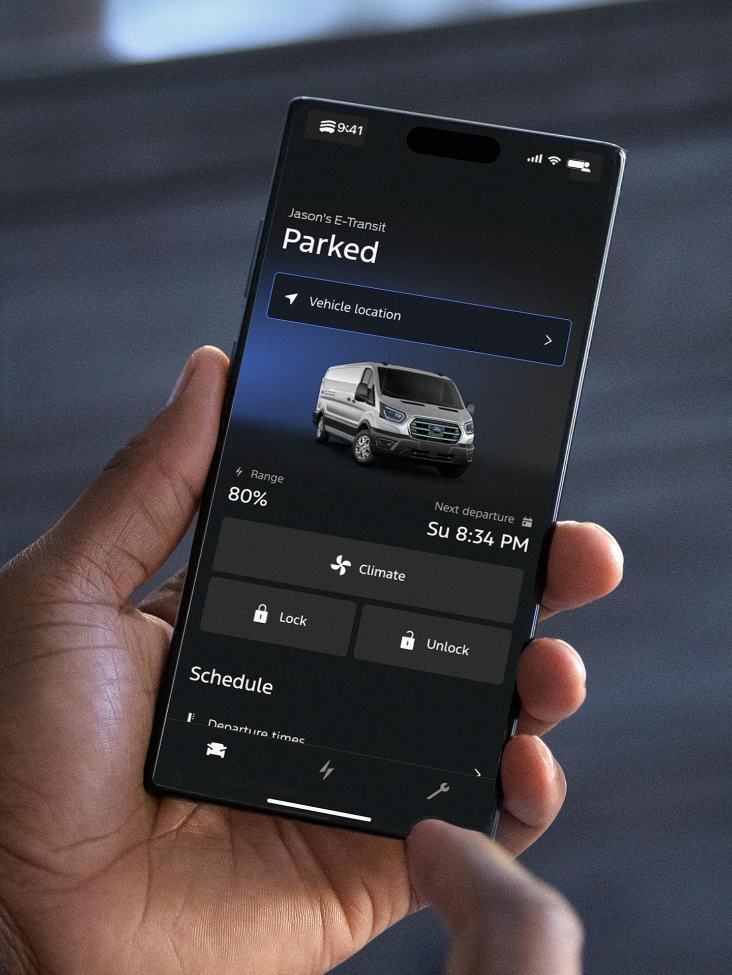 Personne tenant un smartphone sur lequel s'affiche l'état de recharge d'un véhicule.