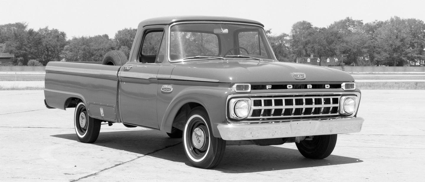 Un camion F-150 1965 dans un stationnement vide.