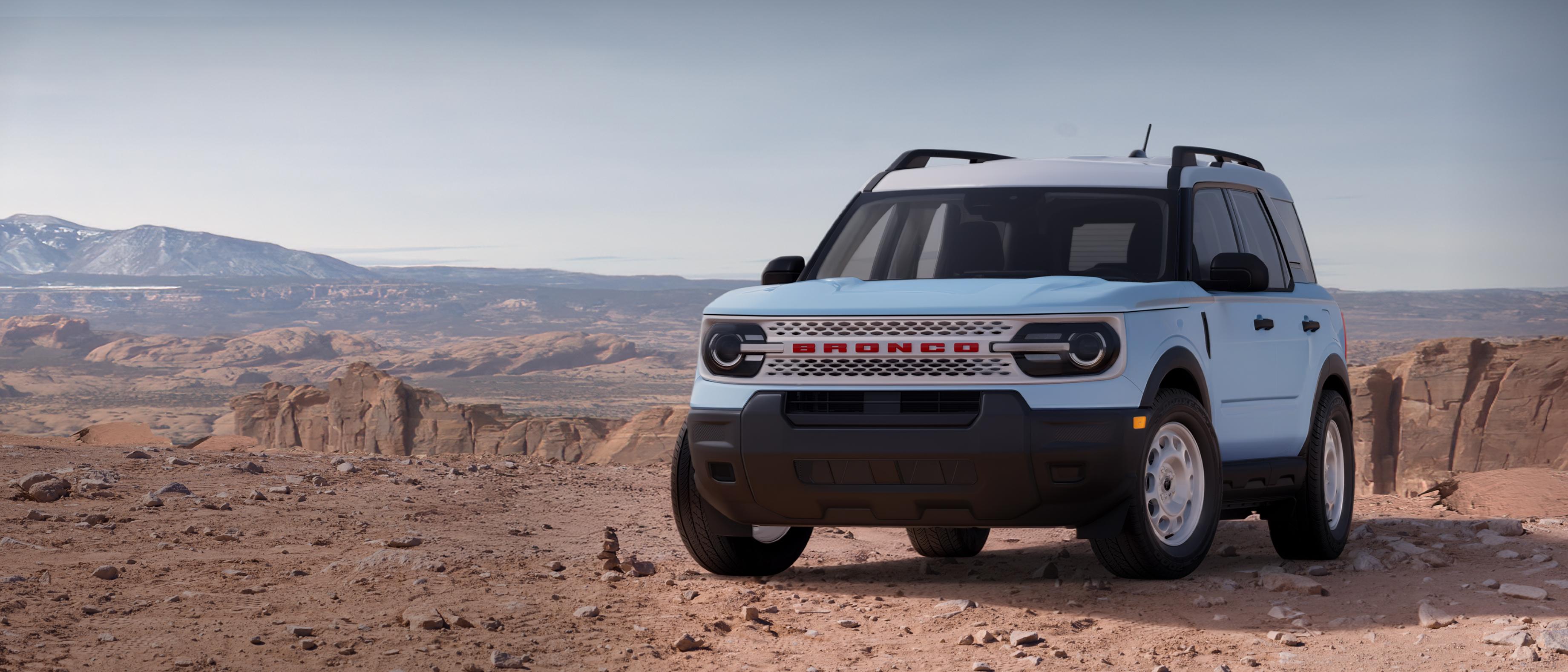 Ford Bronco Sport® modèle Heritage 2026 stationné sur un chemin de terre avec des falaises rocheuses en arrière-plan