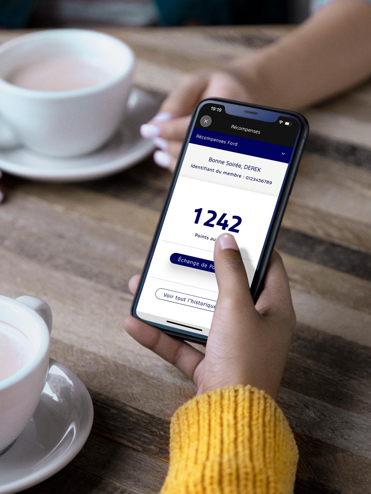 Un téléphone affiche l'application récompenses Ford.