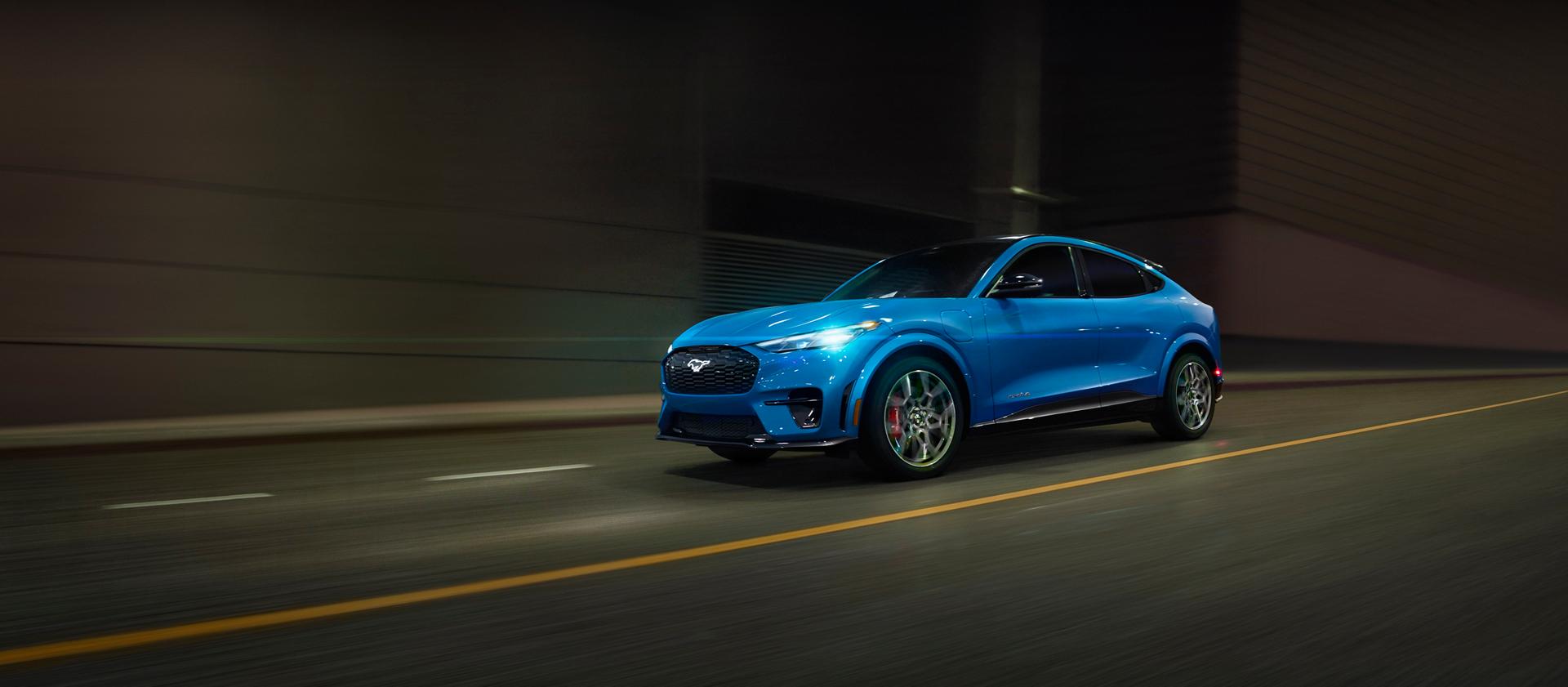 Modèle Ford Mustang Mach-E® 2026 circulant dans une rue de la ville