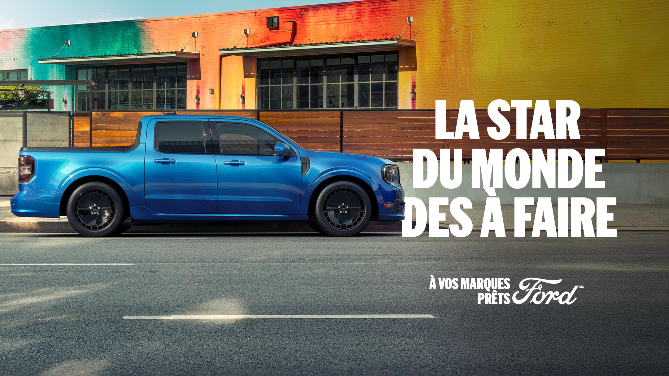 Vue de profil d'un Ford Maverick bleu garé devant un bâtiment coloré de la ville. La star du monde des à faire. À vos marques, prêts, Ford.