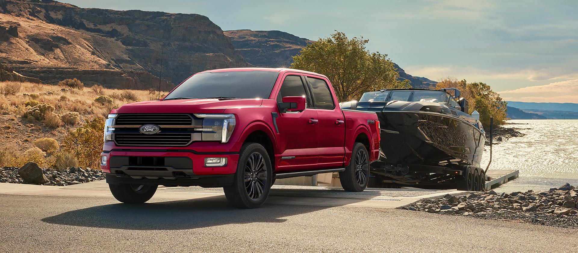 Camionnette Ford F-150® STX® FX4 2026 de couleur rouge rubis tirant un bateau hors de l’eau