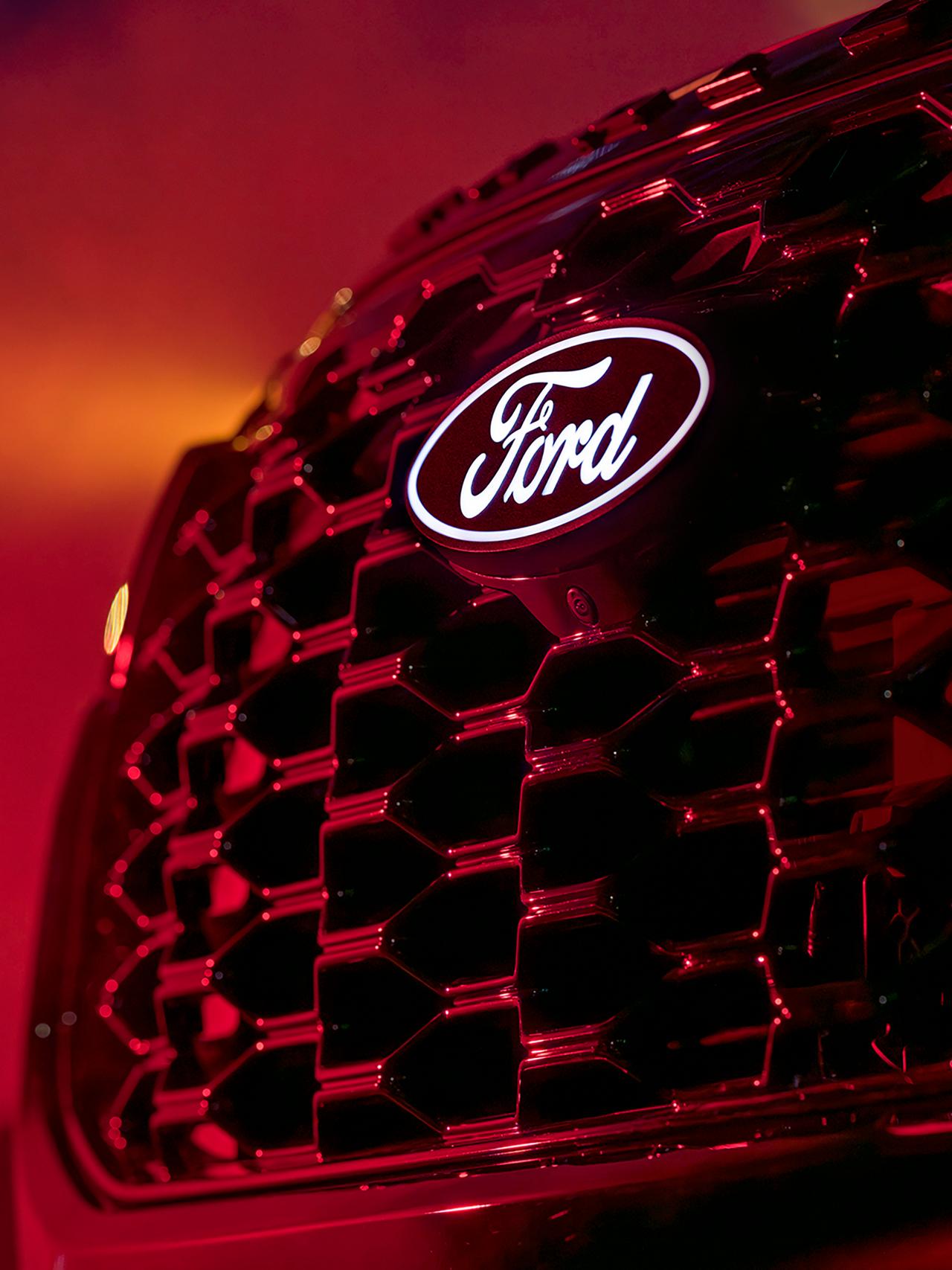 Un gros plan de l’insigne de capot éclairé et de la caméra en option sur un modèle Ford Explorer® ST-Line 2027