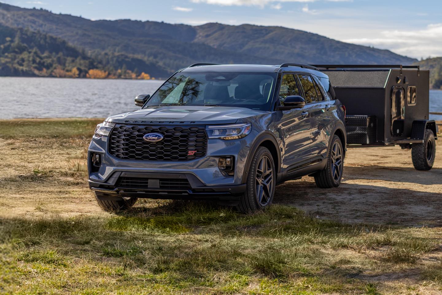 Un Ford Explorer® en gris stationné près d'un lac avec une remorque attachée au coffre