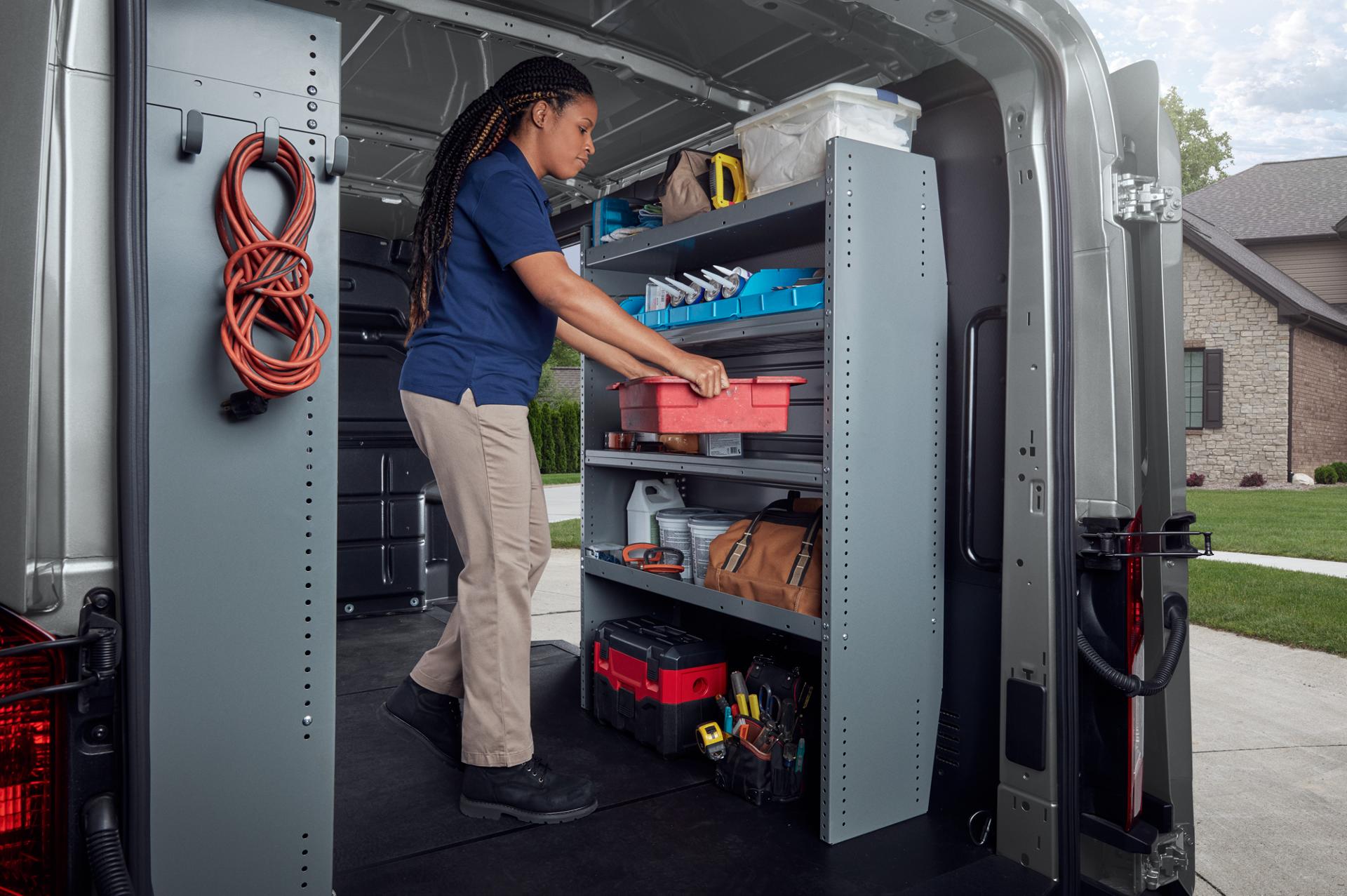 Vue arrière présentant une personne qui travaille à l'intérieur, à l'arrière d'une fourgonnette Ford Transit® de 2027