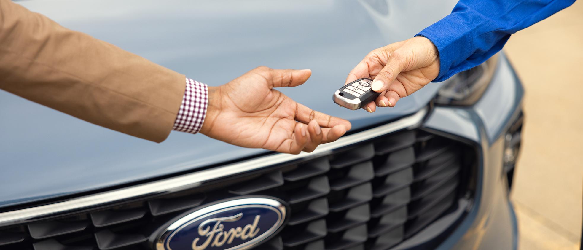 Un représentant de Service Ford tend des clés à un propriétaire Ford.