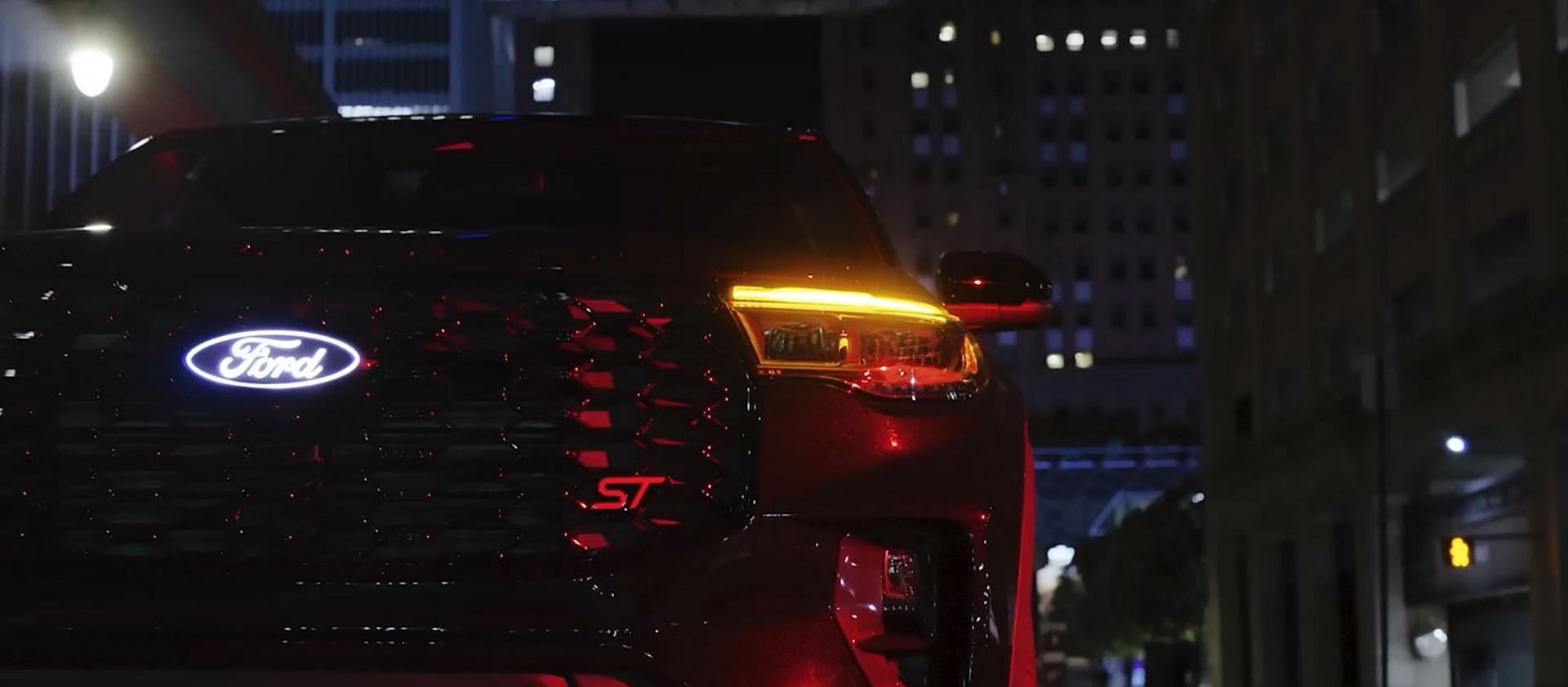 Un Ford Explorer® ST 2027 équipé de l’ensemble Sinister en option, stationné dans une rue brumeuse la nuit