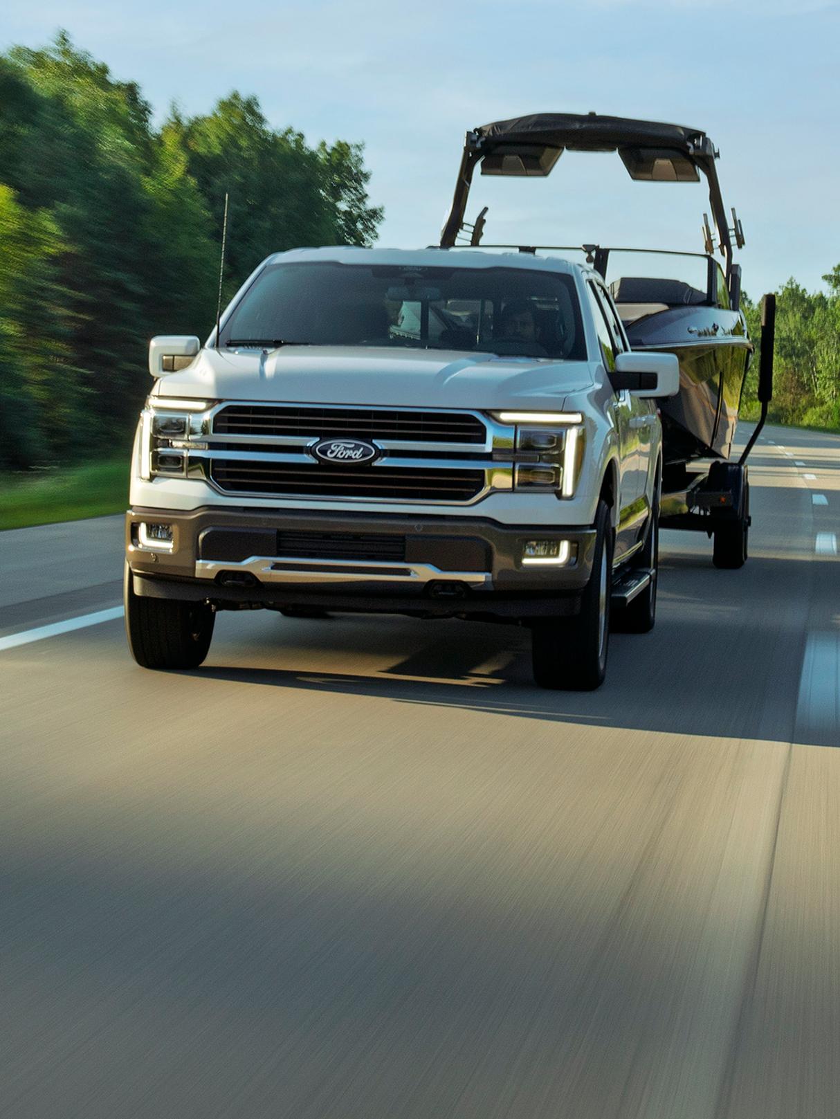 Un camion Ford F-150® Lariat® 2027remorquant un bateau sur une autoroute