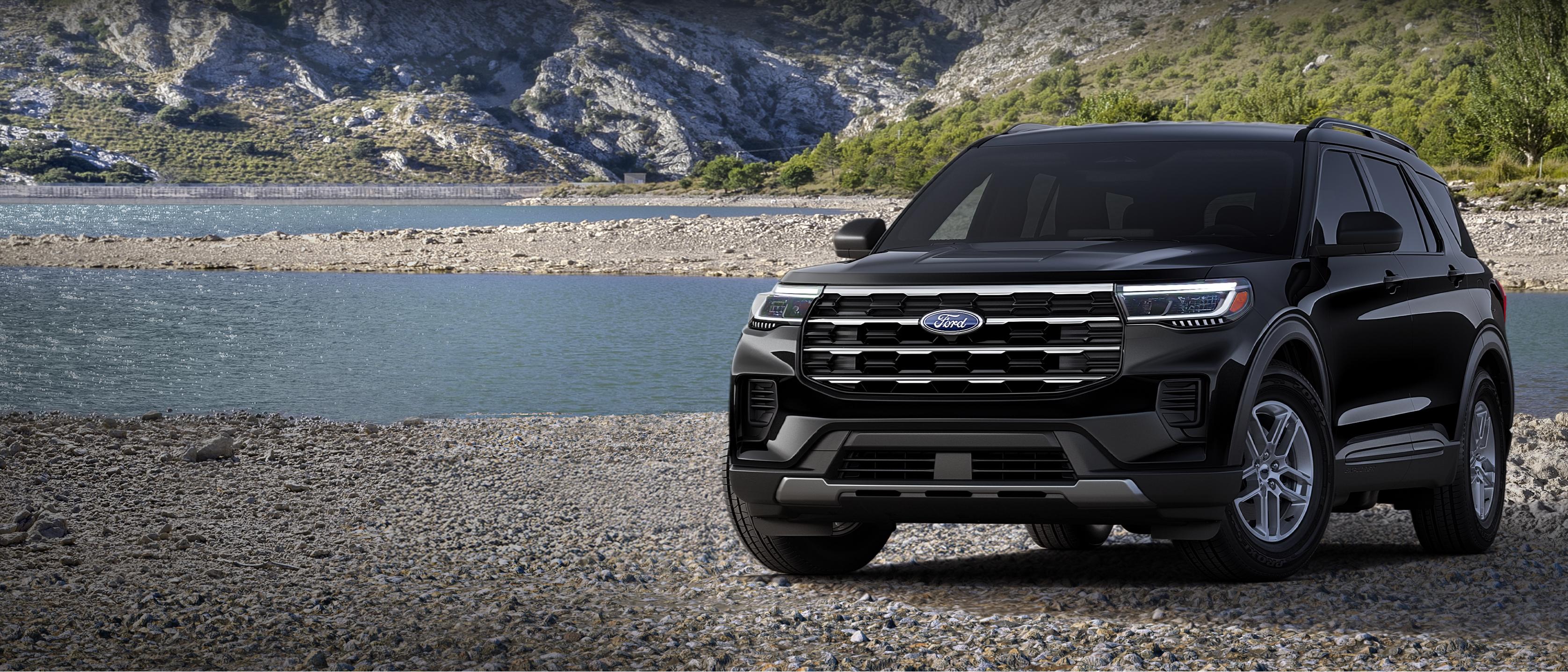 Un modèle Ford Explorer® Active 2026 stationné sur une étendue rocheuse, près d’un lac de montagne