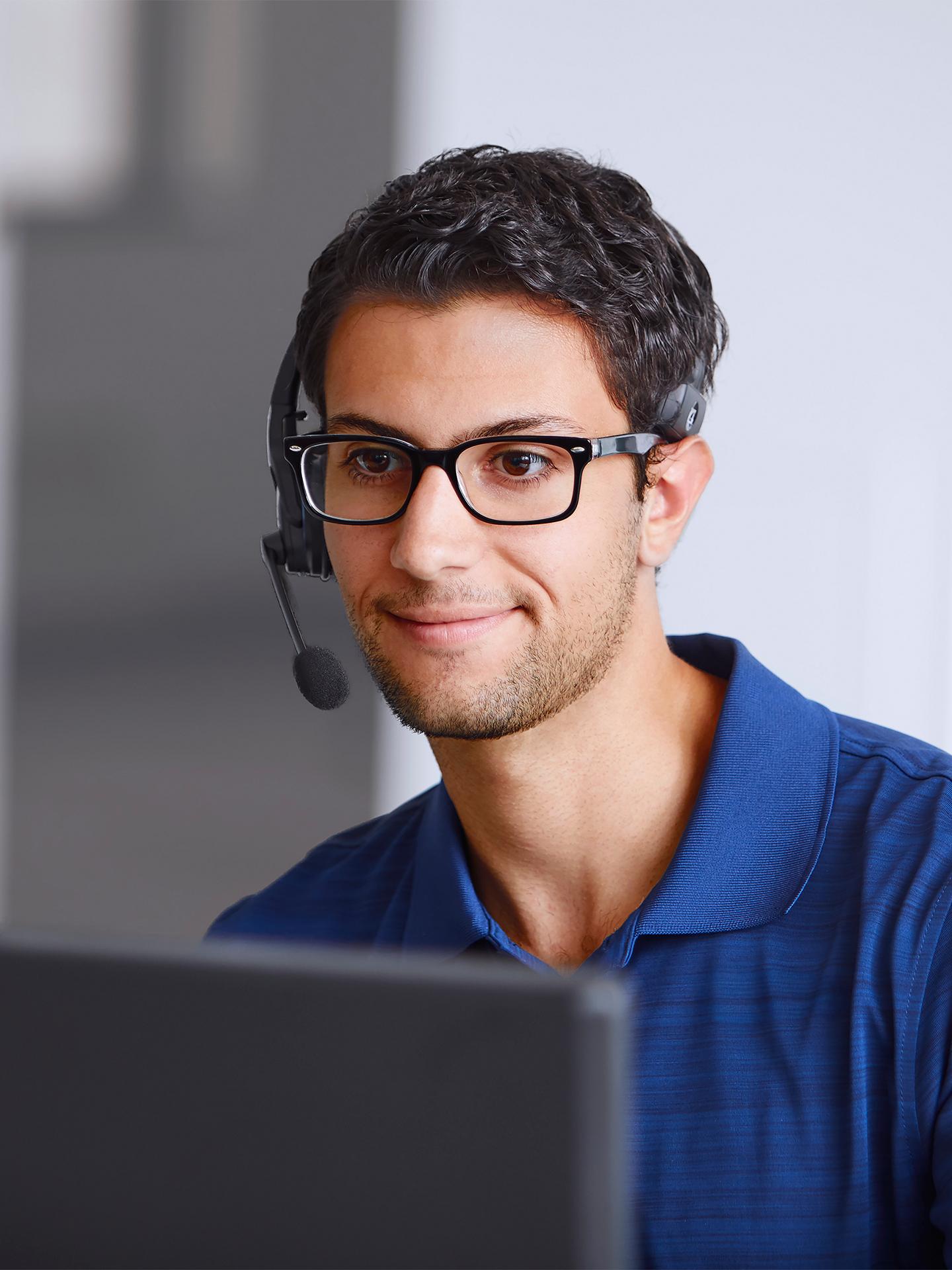 Une personne travaillant dans un centre d’appels et portant des écouteurs.