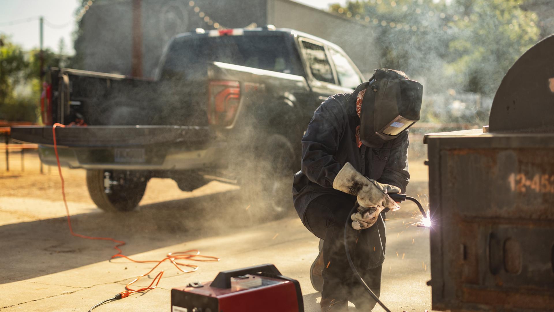 Un soudeur utilisant une machine à souder branchée à la fonction d’alimentation intégrée Pro Power Onboard™