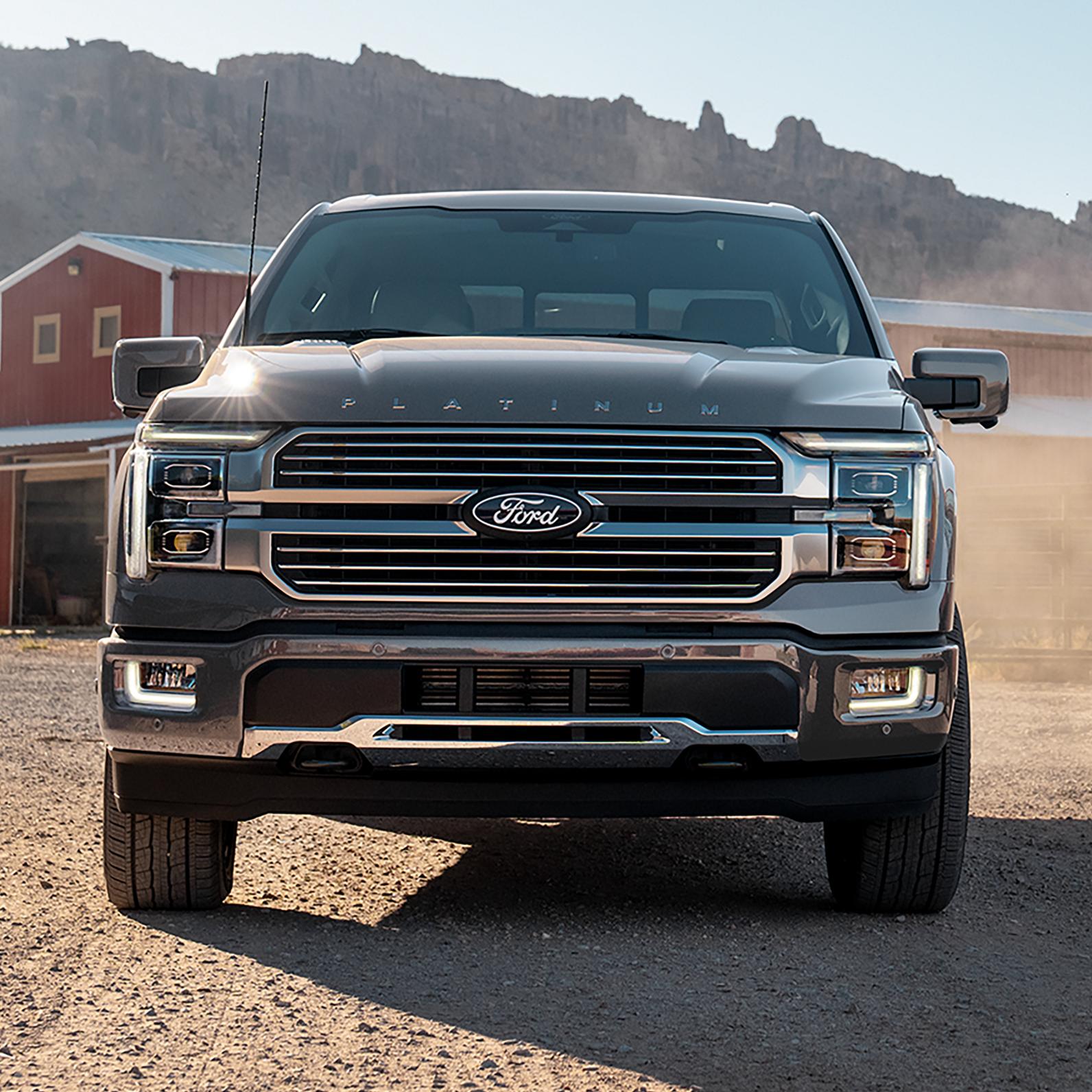 Un Ford F-150® 2025 garé devant une grange et du matériel agricole