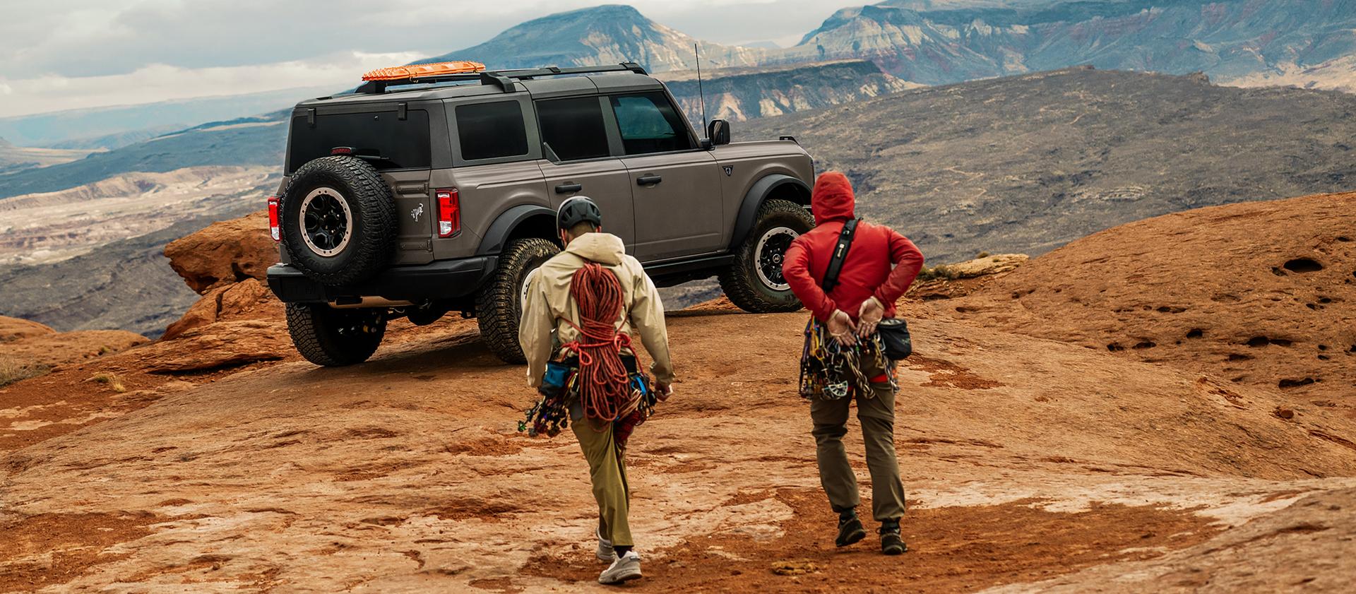 Deux randonneurs s’approchant d’un VUS Ford Bronco® 2026 stationné près d’un belvédère