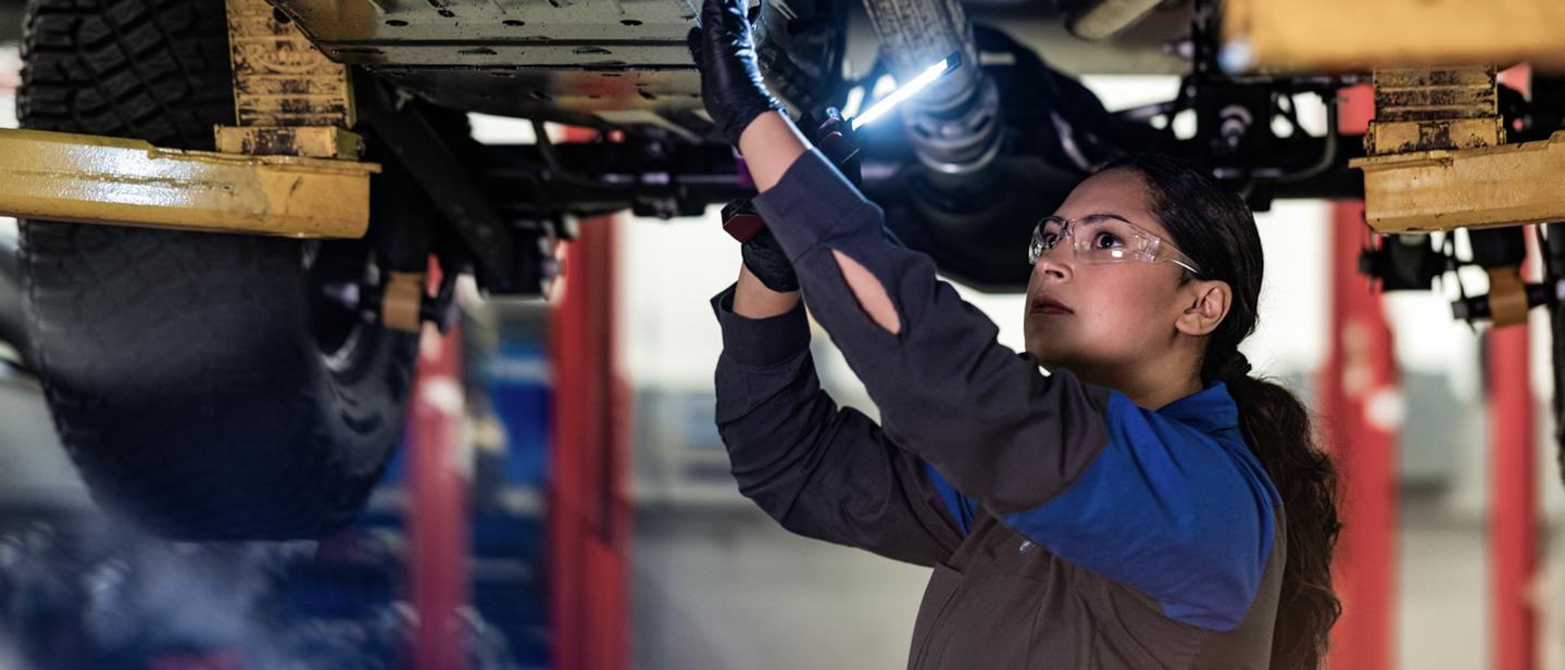 Un technicien Ford travaille sous le châssis d’un véhicule
