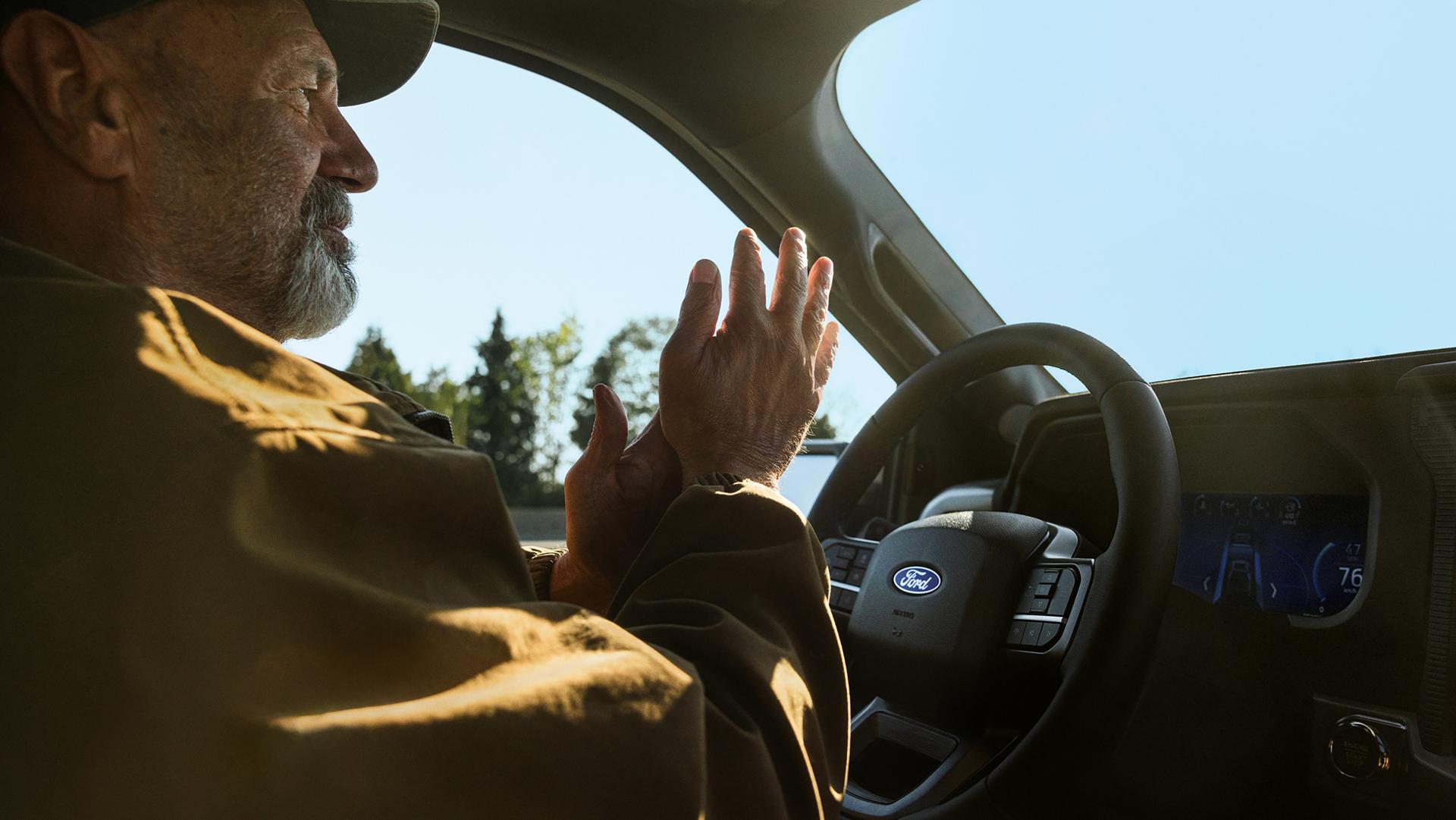 Homme utilisant la fonction de conduite mains libres sur autoroute Ford BlueCruise sur une camionnette Ford F-150® 2026